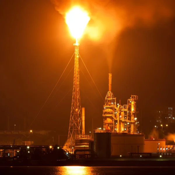 Refinaria de petróleo à noite com uma enorme coluna de smike poluindo o ar — Fotografia de Stock