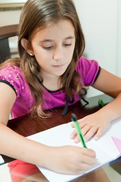 Malé hispánský dívka pracuje na její domácí úkoly — Stock fotografie