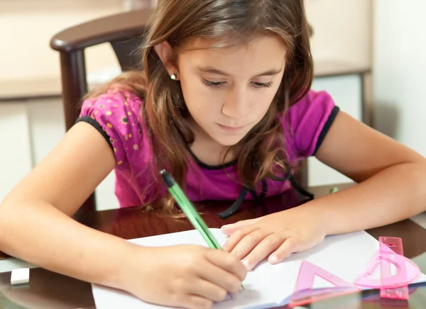 Kleines hispanisches Mädchen, das an ihren Hausaufgaben arbeitet — Stockfoto