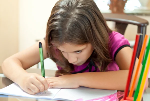 Malé hispánský dívka pracuje na její domácí úkoly — Stock fotografie