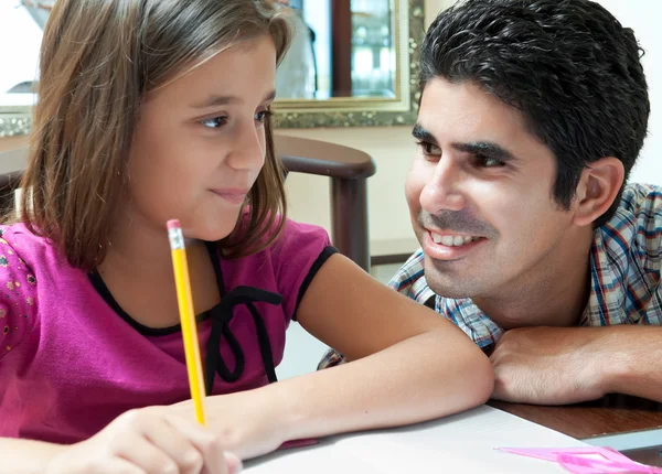Giovane latino raccogliere aiutando la figlia con i compiti — Foto Stock