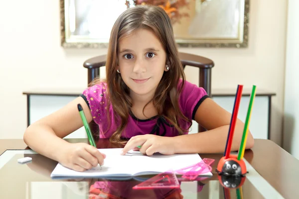 Маленькая латиноамериканка работает над своим домашним заданием — стоковое фото