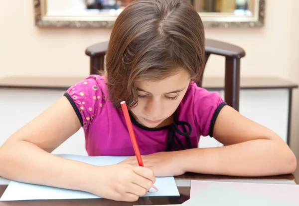 Small hispanic girl working on her school project at home — Stock Photo, Image