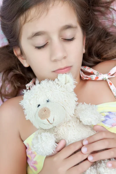Belle fille hispanique qui couche avec son ours en peluche — Photo
