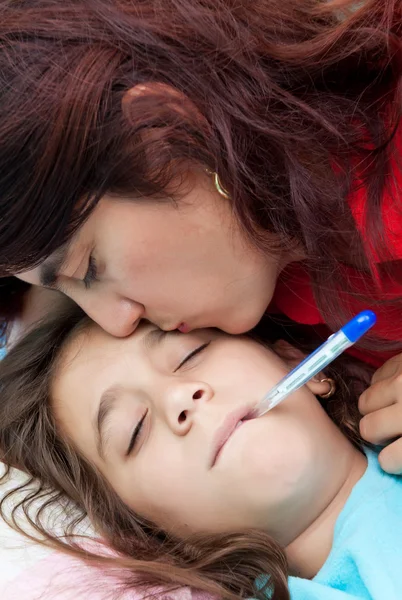 İspanyol annesi hasta küçük kızı sıcaklığını kontrol — Stok fotoğraf