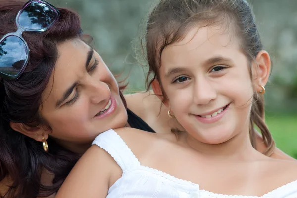 Beautiful young hispanic mother with her daughter in a park — Stock Photo, Image