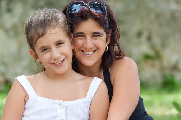 Güzel genç İspanyol anne ile kızının bir parkta — Stok fotoğraf