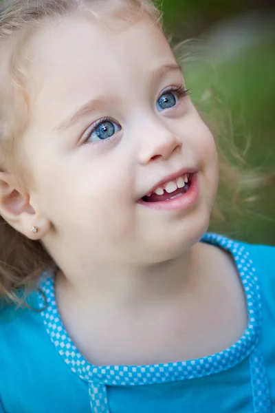 Κοριτσάκι χαμογελώντας με φόντο ένα χόρτο — Φωτογραφία Αρχείου