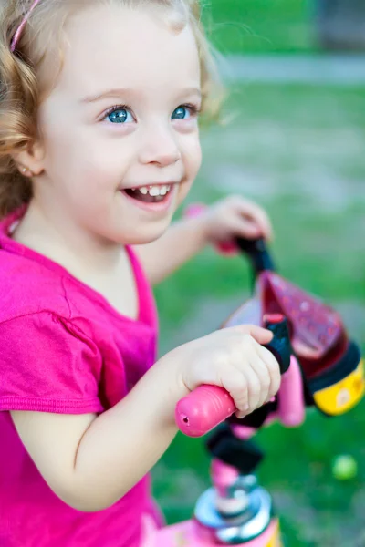 Malé děvče, jezdit na kole v parku — Stock fotografie
