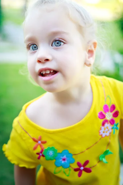 Krásná malá dívka s modrýma očima v parku — Stock fotografie