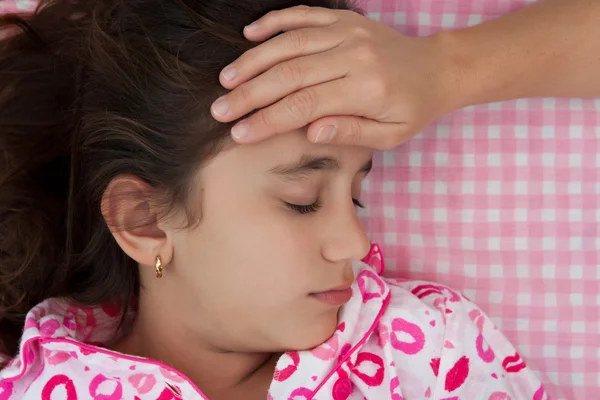 Nemocní s horečkou v posteli hispánský dívka — Stock fotografie