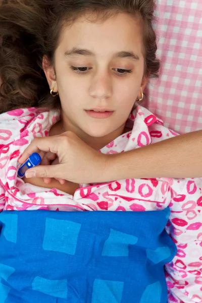 Chica hispana enferma de fiebre tendida en su cama —  Fotos de Stock