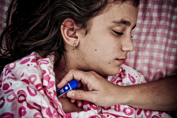 Маленькая девочка в постели больна лихорадкой — стоковое фото