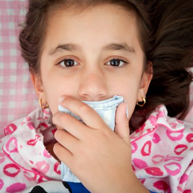 Small girl sick with the flu covering her mouth clipart