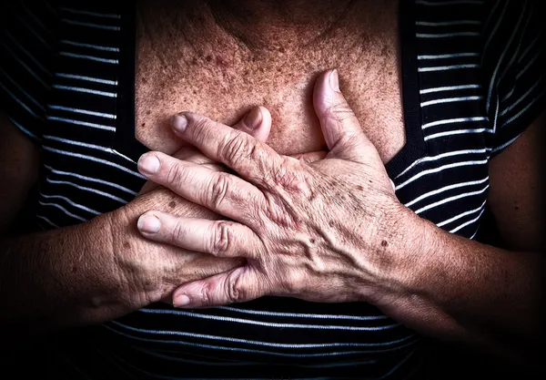 As mãos da mulher envelhecida sobre o peito — Fotografia de Stock