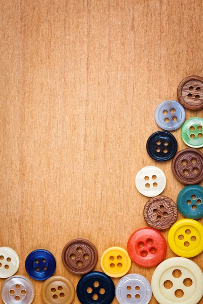 木製の背景にカラフルな縫製ボタン — ストック写真
