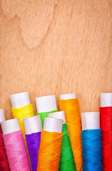 Sewing thread reels on a wood background — Stock Photo, Image