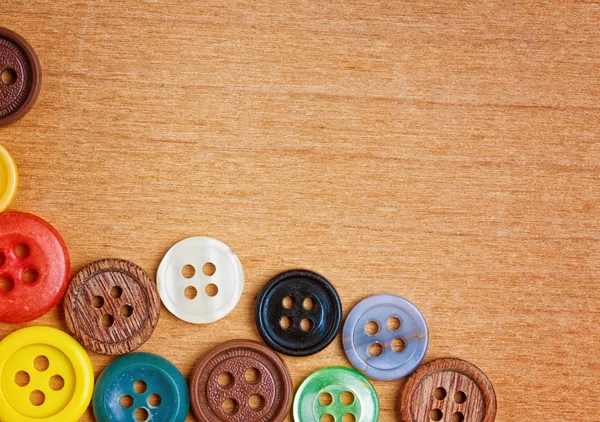 Przyciski kolorowe do szycia na tle drewna — Zdjęcie stockowe