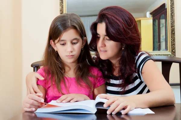 Menina lendo um livro com sua bela mãe — Fotografia de Stock
