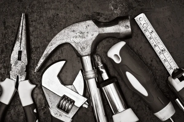 Kit de herramientas en blanco y negro sobre fondo metálico — Foto de Stock