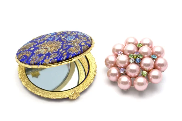 Cosmetic mirror and brooch — Stock Photo, Image