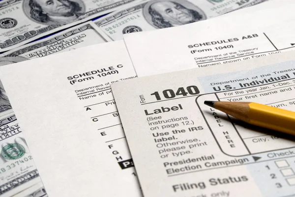 Formulários fiscais em cima do dinheiro — Fotografia de Stock