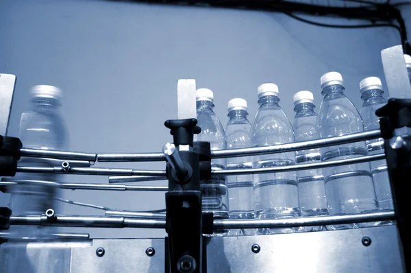 Vattenflaskor på transportband — Stockfoto