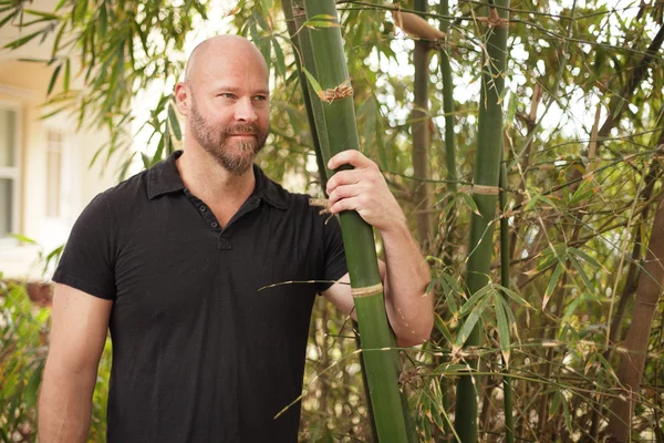 Man die zich voordeed in een bamboe tuin — Stockfoto