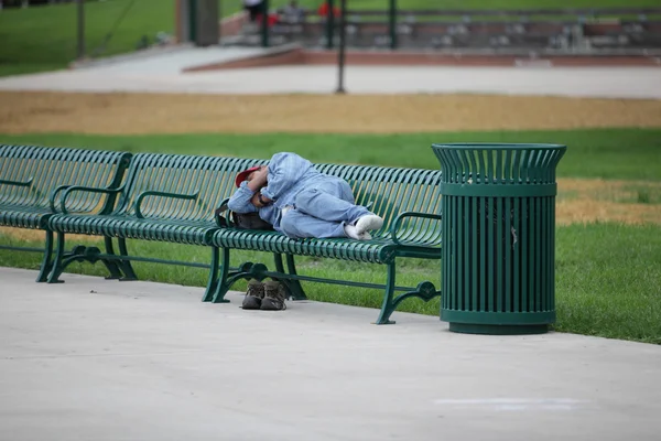 Hemlös person sova på bänken — Stockfoto