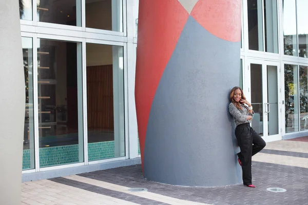 Woman leaning on a building column — Stock Photo, Image