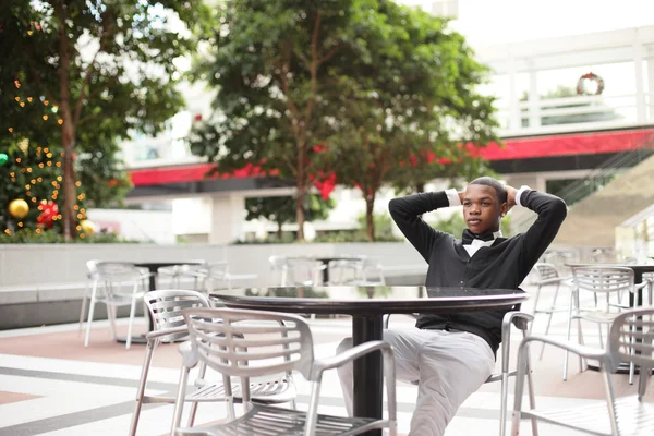 Schöner schwarzer Mann entspannt sich an einem Tisch — Stockfoto