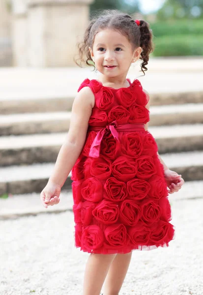 Criança em um vestido de flor vermelha — Fotografia de Stock