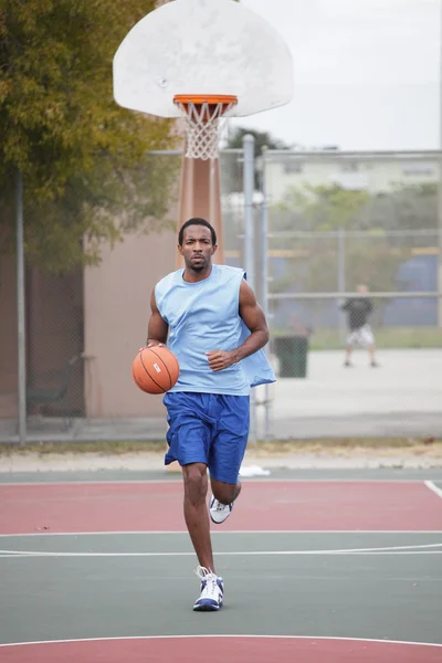 Баскетболист бегает и капает мяч — стоковое фото