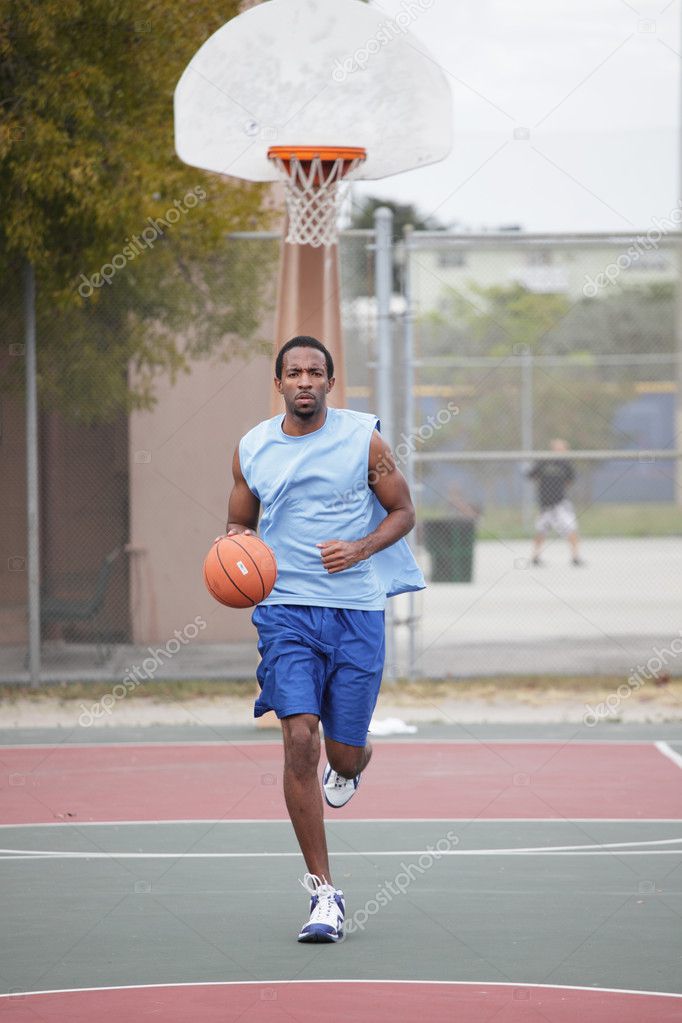 Basketball player running and dribbling the ball