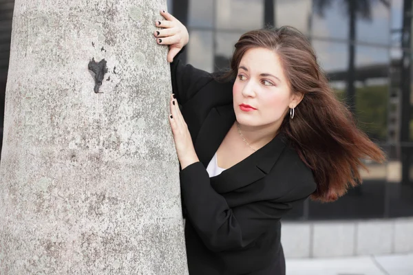 Zakenvrouw achter een boom — Stockfoto