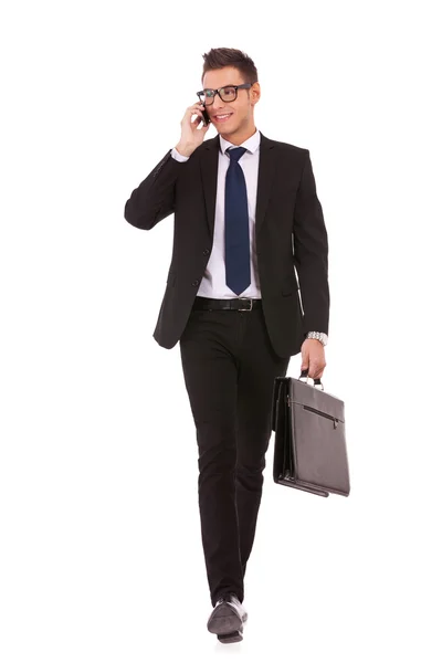 Obchodní muž chodí a mluví na telefonu — Stock fotografie