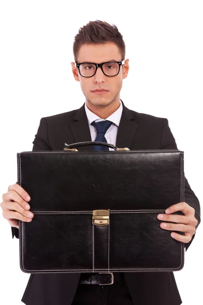 Hombre de negocios serio ofreciendo un maletín — Foto de Stock