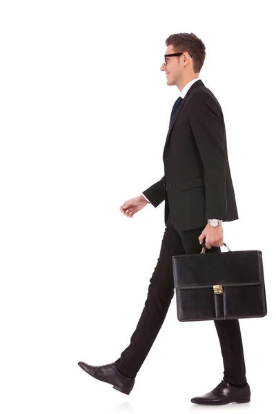 Hombre de negocios sosteniendo breve caso y caminando —  Fotos de Stock