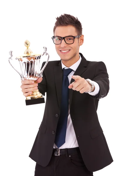 Homem de negócios segurando um troféu e apontando — Fotografia de Stock