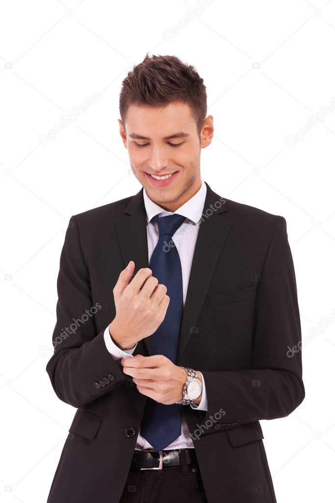 Smiling business man buttoning his sleeve