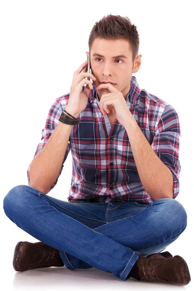 Fundersam man sitta och prata i telefon — Stockfoto