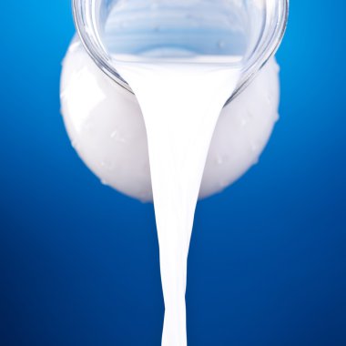 Closeup of a jug with pouring milk clipart