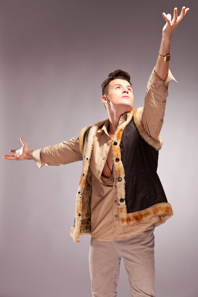 Man in a fur coat reaching out for the light