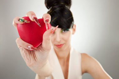 Woman holding heart in one hand clipart