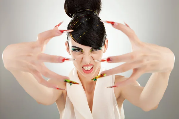 Chica morena enojada muestra sus uñas de los dedos —  Fotos de Stock