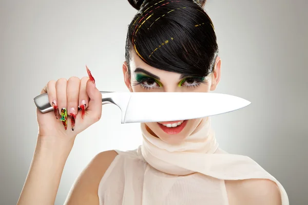 Kvinna med en kniv över hennes ansikte — Stockfoto