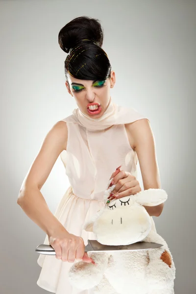 Женщина режет шею своему плюшевому мишке — стоковое фото