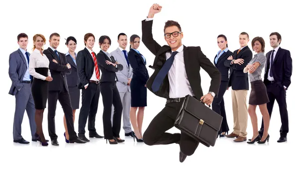 Geschäftsmann mit Aktentasche springt vor seinem Team — Stockfoto
