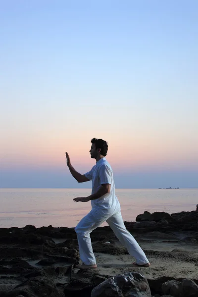 Stilig man tränar thai chi på stranden — Stockfoto