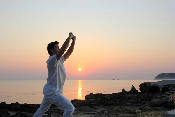 Hombre guapo practicando tailandés chi en la playa — Foto de Stock